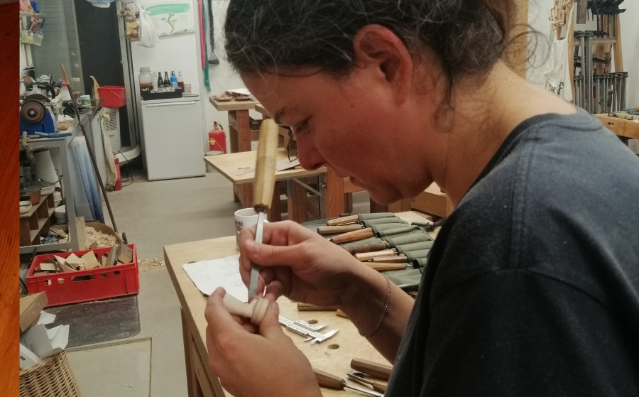 Schnitzerische Arbeit an den Figuren des Terminator Schachsets, Astrid Unterberger schnitzt