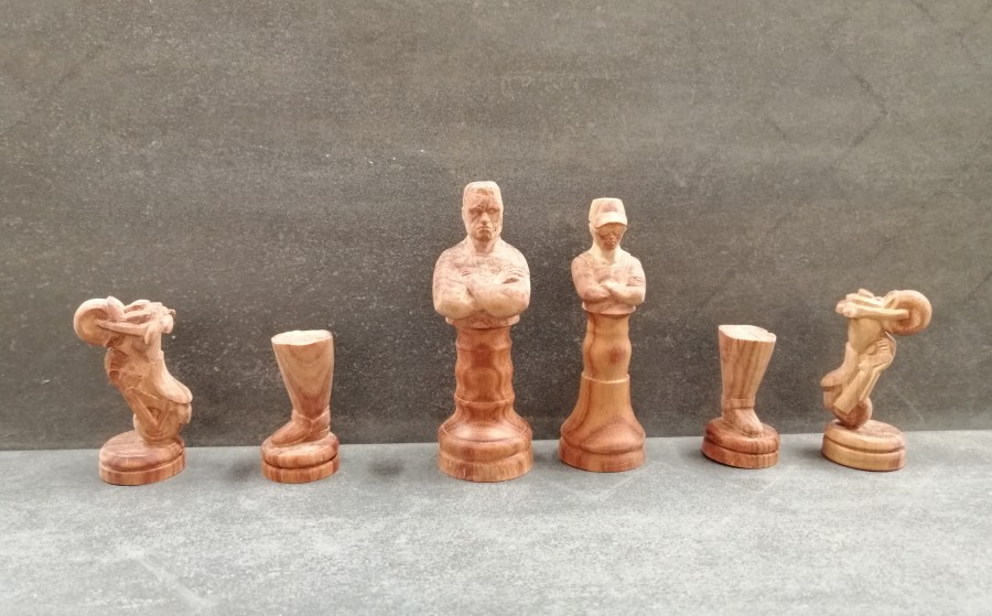 Die Terminator Schachfiguren in Rosenholz (rot): Terminator ist der König, Sarah Connor ist die Dame, das Motorrad ist das Pferd, der Stiefel ist der Läufer