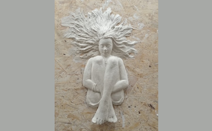 ein Reliefbild eines sitzenden Mädchens in Gips - unfertig